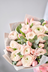 Bunch pale pink tulips and ranunculus flowers with green eucalyptus. The work of the florist at a flower shop.