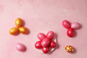 Decorated golden easter eggs on a pink background. Minimal holiday concept. Happy easter background. Creative painting of eggs at home, the idea of simple drawings for coloring, a place for text,