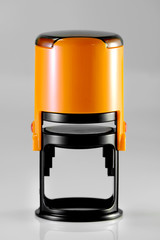 A self-inking round automatic office rubber stamp. Modern plastic rubber stamp on a gray background. A paperwork. Office accessories.Notary public concept and business concept. 