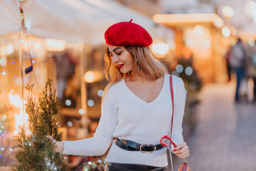 Beautiful young girl in a festive setting. In the circle of it flickering lights. Charm adds her...
