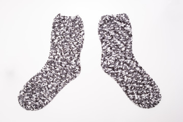 Grey motley cozy winter socks on white background
