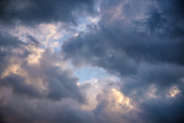 Fototapeta na wymiar Dark heavy clouds after the rain has formed a divine gap of light and sun.