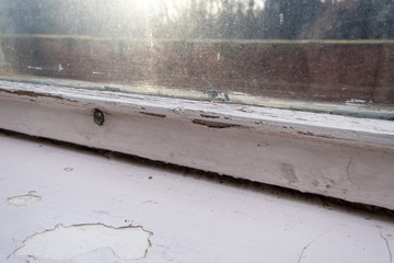 Old wooden window with peeling paint and durt needed to be repaired or replaced