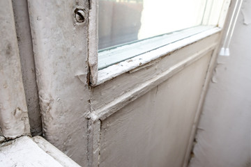 Obraz premium Old wooden window with peeling paint and durt needed to be repaired or replaced