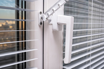 A handle and a restrictor, window stopper or limiter on PVC double glazed window with horisontal...