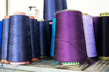 Colorful thread reels set up for sewing machine, textile industry factory concept
