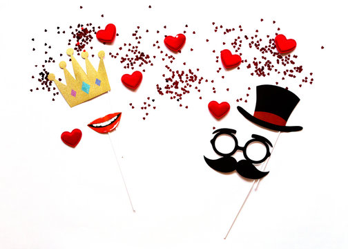 flatlay false paper photo stand props: crown lips, mustache and hearts white background copyspace for Valentine's day greeting card