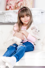 child hugs a white terrier puppy