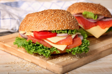 Hearty appetizing fish hamburgers in plates on the table
