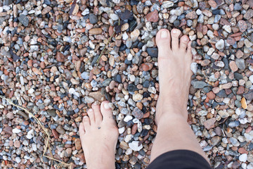 Walking barefoot on a rocky beach.