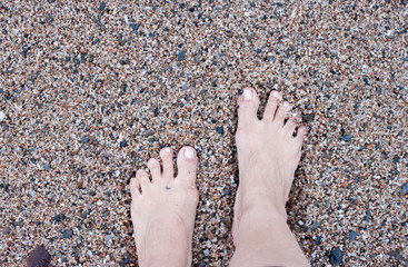 Walking barefoot on a rocky beach.