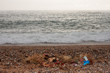 Fototapeta na wymiar On the beach is colored plastic and garbage