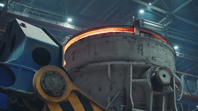 Close up of blast furnace with hot melted steel inside, glowing orange 