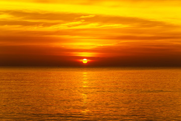 sunset with large yellow sun under the sea surface