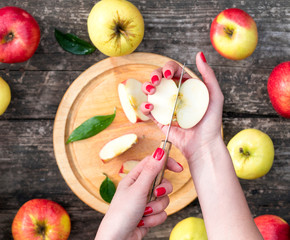 woman cuts an apple on a wooden board. cooking food. top view