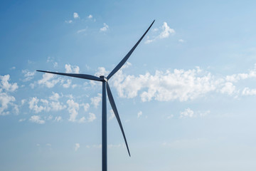 Wind turbine generate electricity on blue sky background. Energy conservation concept. Producing alternative energy
