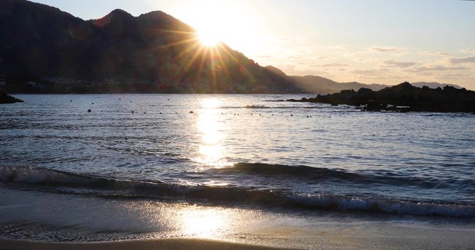 Beautiful sunset on the sea with splashing waves. Sunlight is reflected in the water. Seascape on the island of Cyprus. Sun Rays Over Kyrenia Mountains. 4k video 4096X2160