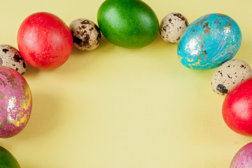 Top view painted eggs Easter Frame in circle shape on a yellow background. Copy space