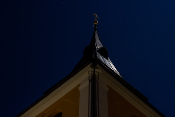 Detail of night illuminated historic Catholic church in moonlight