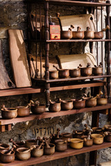 Wooden handmade kitchenware on racks for sale in the market of ancient streets of European cities. Selective focus of bowls with spoons and plates in rustic style in brown colour at traditional Fair