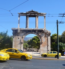 Hadrians Arch Athens Greece surrounded by yellow taxis