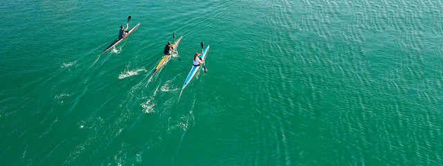 Aerial drone ultra wide photo of women athletes competing in sport canoe in tropical exotic lake