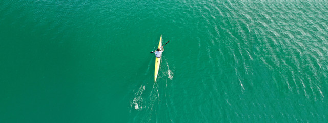 Aerial drone ultra wide photo of women athletes competing in sport canoe in tropical exotic lake
