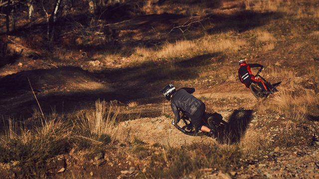 two mountain bike riders go round turns
