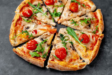 tasty italian pizza with mozzarella cheese, mushrooms, tomato, bell pepper, onion on a stone background
