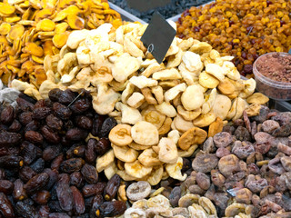 A variety of dried fruits are on the counter. Mock-up price tags are black.