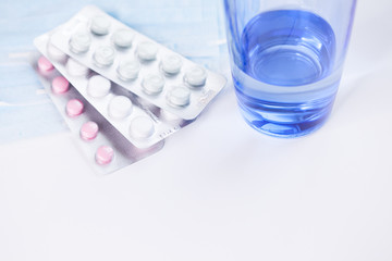 Medications pills drug, mask and glass of water. Flu outbreak and coronavirus or influenza.