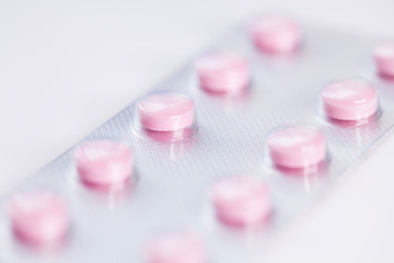 Close up of pink  tablets, pills in blister pack, medications drugs, macro, selective focus