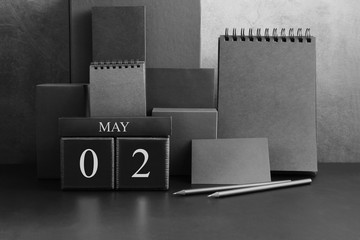 May 2th. Day 2 of month. Wood cube calendar with date month and day. Trendy classic black color. Lot of empty pages template for daily notes.