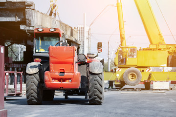Constuction site heavy machinery industrial background. Telescpic handler vehicle and big mobile...