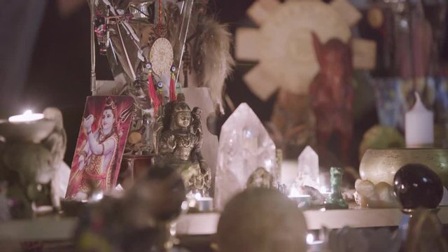 Close up of Feng Shui altar at home in living room on the table. Art. Attracting wealth and prosperity concept, rystal clusters, golden Buddah figure and candles.