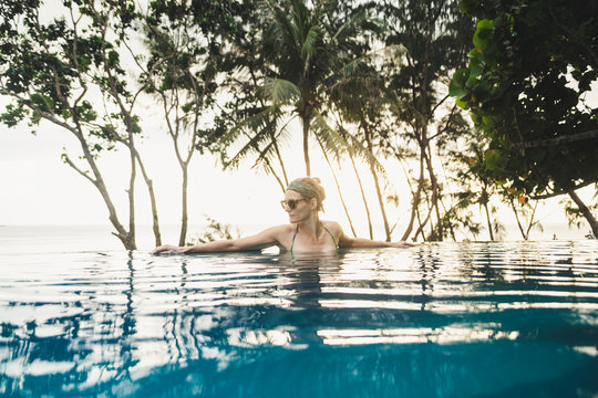 Woman in infinity pool at sunset, Nai Thon Beach, Phuket, Thailand