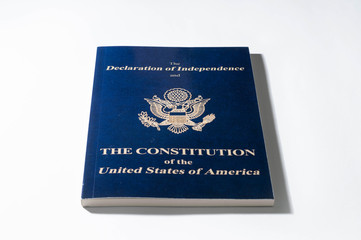 high angle view of blue booklet with declaration of independence and constitution of united states of america on white background