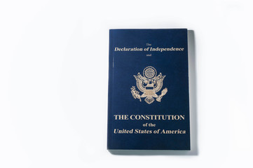 top view of blue booklet with declaration of independence and constitution of united states of america on white background