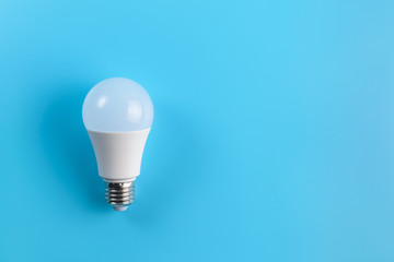 One energy saving white led light bulb on a blue background. Eco power concept.