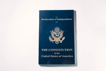 top view of blue booklet with declaration of independence and constitution of usa on white