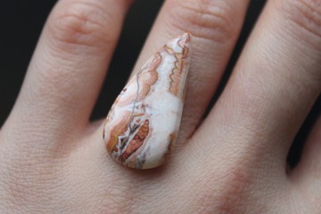 Crazy Lace Agate mineral (banded chalcedony, microcrystalline quartz) with red and brown frilly pattern, mined in Mexico. Oval shaped polished cabochon is ready for setting in jewellery.