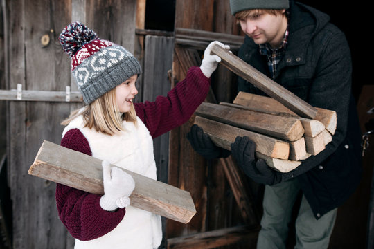 Daughter giving firewood to her father in winter