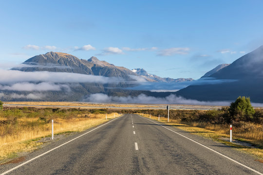 New Zealand, Fog floating over empty State Highway 73 with mountains in background