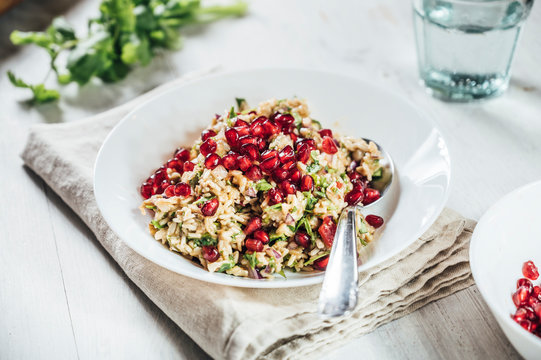 Plate of baba ghanoush salad with brown rice and pomegranate seeds