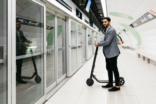 Young businessman with electric scooter in subway station