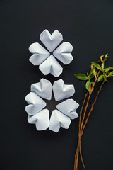 white color paper hearts shape figure eight 8 on black background with flowers