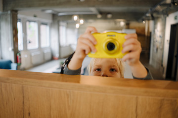 Boy taking a picture with a camera in office