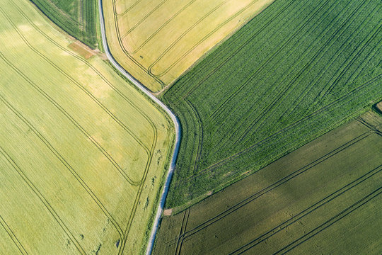 Germany, Bavaria, Franconia, Aerial View Of Green Fields And Dirt Road