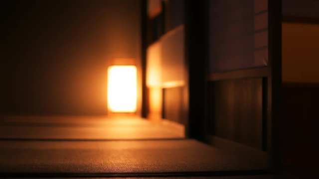 Slow motion of traditional Japanese house ryokan closeup with tatami mat floor, shoji sliding paper doors and woman in kimono and geta shoes tabi socks walking in corridor hall room