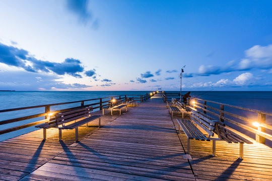 Germany,?Mecklenburg-Western Pomerania, Prerow, Illuminated pier at dusk with clear line of horizon over Baltic Sea in background